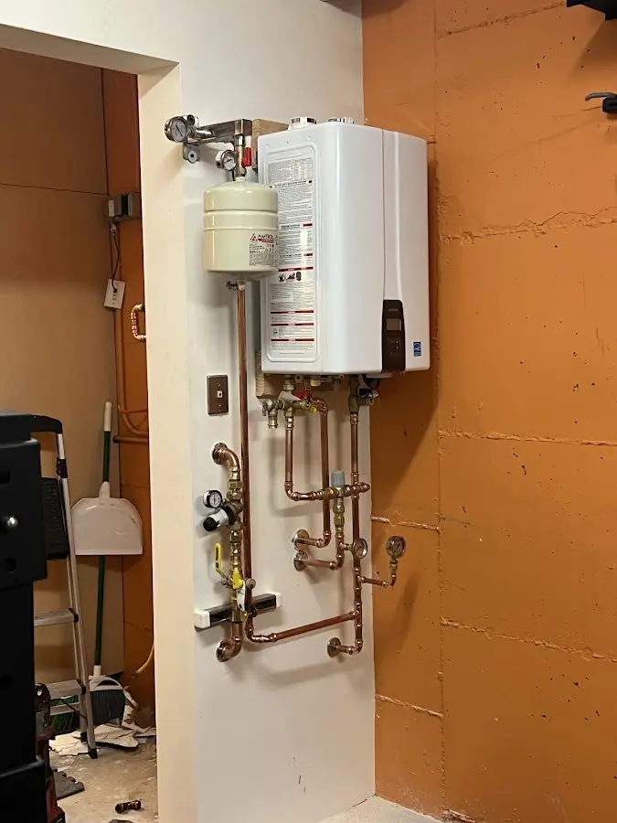 Plumbing technician inspecting water heater connections in Elburn